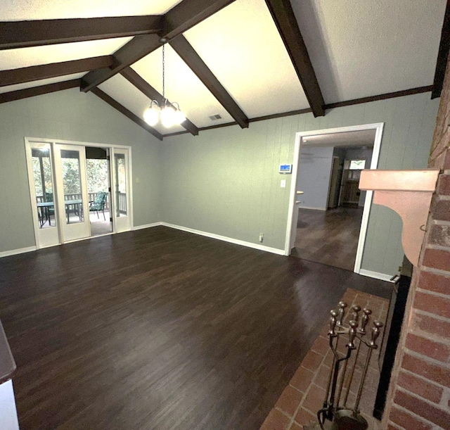 unfurnished living room with dark hardwood / wood-style flooring, wooden walls, lofted ceiling with beams, and an inviting chandelier