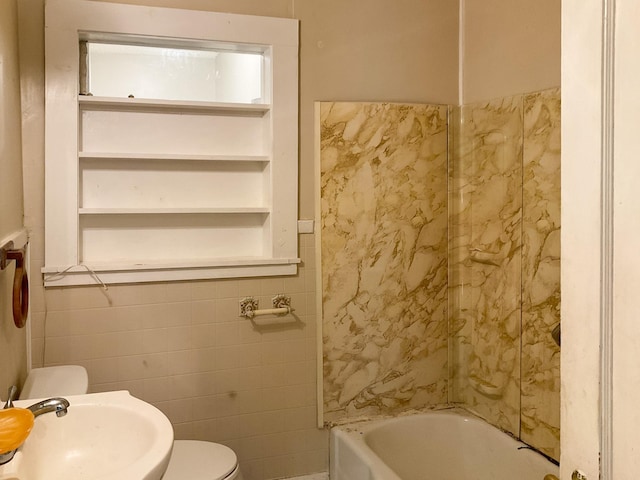 bathroom featuring toilet, sink, and tile walls