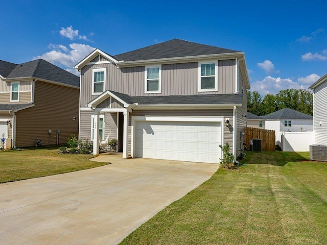 view of front of home with a garage, cooling unit, and a front lawn