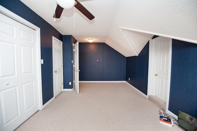 bonus room featuring ceiling fan, light colored carpet, and lofted ceiling