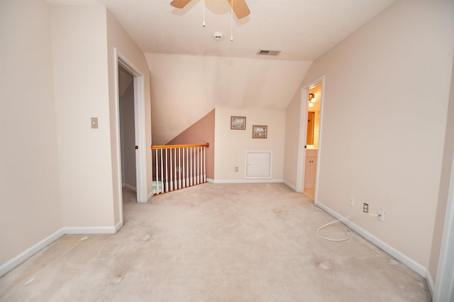 bonus room with lofted ceiling, ceiling fan, light colored carpet, and a textured ceiling