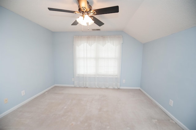 carpeted empty room with vaulted ceiling and ceiling fan