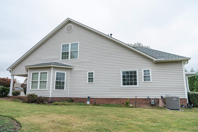 view of side of home with a lawn and central air condition unit