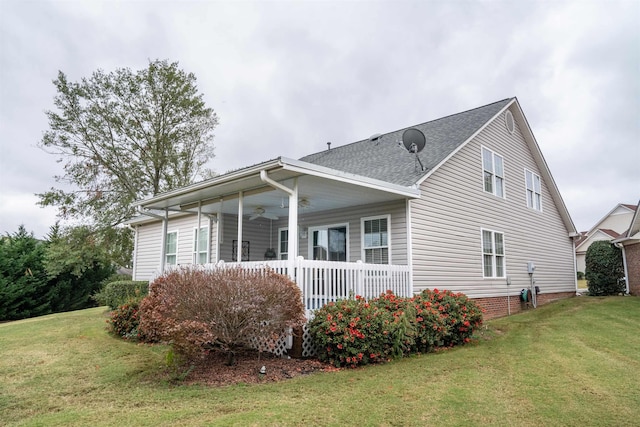 exterior space featuring a porch, ceiling fan, and a lawn