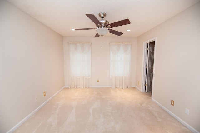 carpeted spare room featuring a textured ceiling and ceiling fan