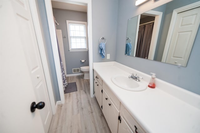 bathroom featuring vanity, hardwood / wood-style floors, and toilet