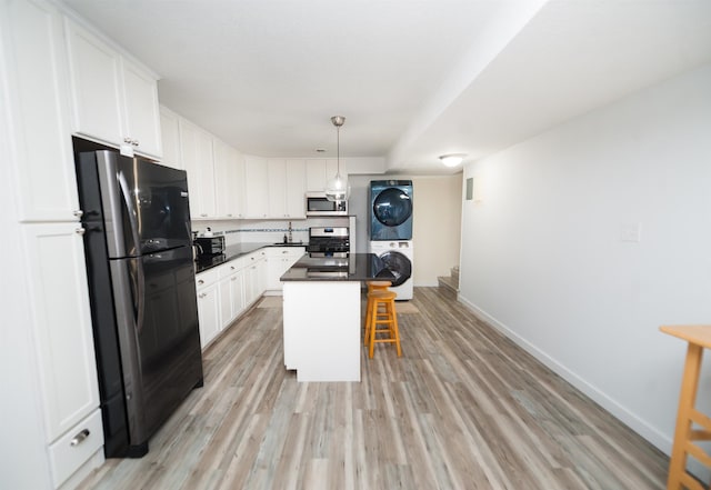 kitchen with a kitchen island, appliances with stainless steel finishes, a breakfast bar, white cabinetry, and stacked washer and clothes dryer