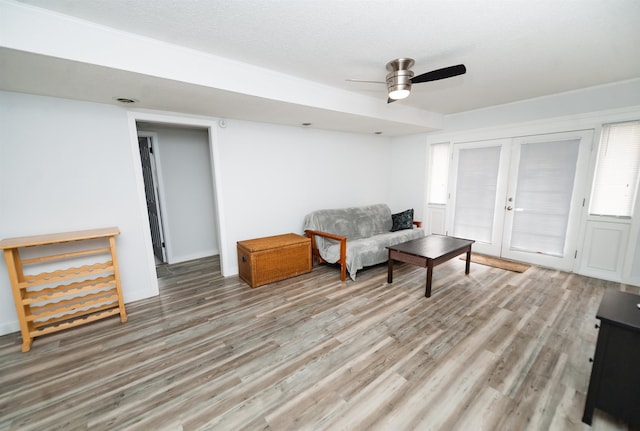 living area with french doors, ceiling fan, and light wood-type flooring