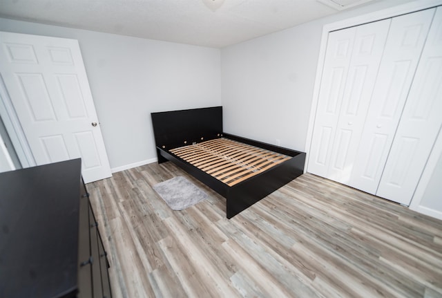 unfurnished bedroom featuring light hardwood / wood-style flooring and a closet