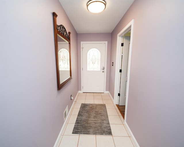 doorway with light tile patterned flooring