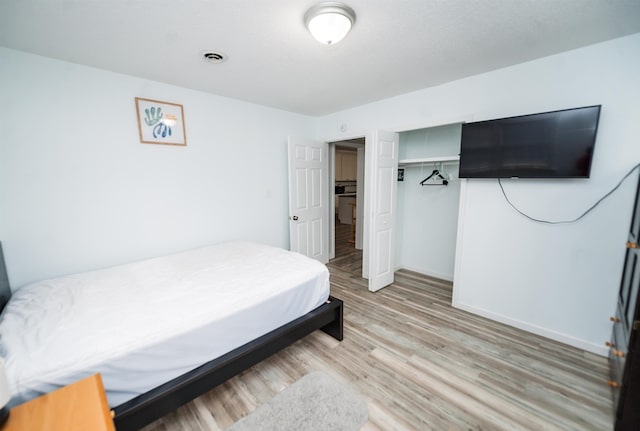 bedroom with wood-type flooring and a closet