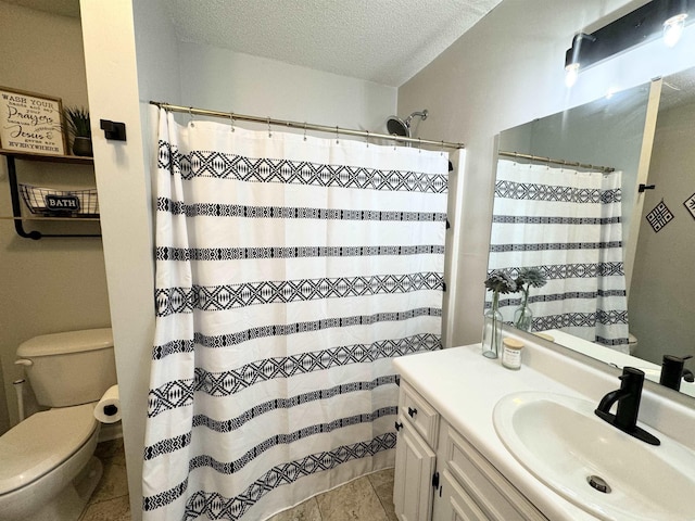 bathroom with vanity, toilet, and a textured ceiling