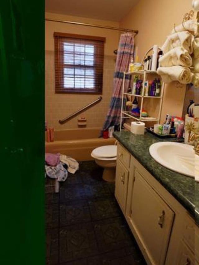 full bathroom featuring vanity, shower / bath combination with curtain, and toilet