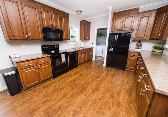 841 Browning, Enoree, SC 29335 - kitchen featuring washing machine and clothes dryer, sink, ornamental molding, dark hardwood / wood-style floors, and black appliances