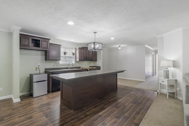 kitchen featuring a kitchen island, dark hardwood / wood-style floors, hanging light fixtures, fridge, and dark brown cabinets