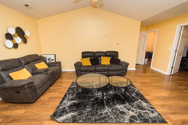 living room featuring lofted ceiling and hardwood / wood-style floors