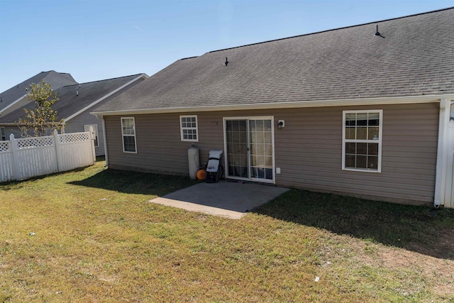 rear view of house with a patio and a yard