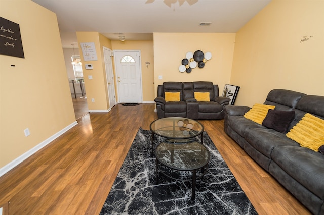 living room with dark wood-type flooring and ceiling fan