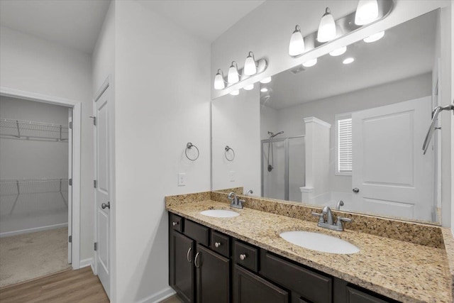 bathroom featuring an enclosed shower, vanity, and hardwood / wood-style floors