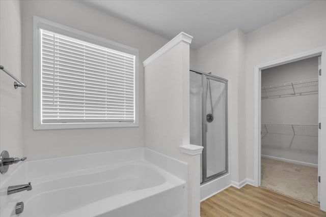 bathroom featuring wood-type flooring and separate shower and tub