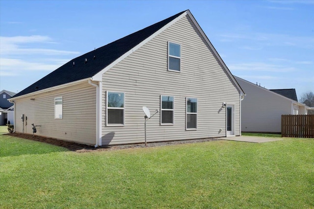 back of house with a patio area and a lawn