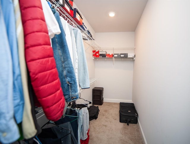 walk in closet with light colored carpet