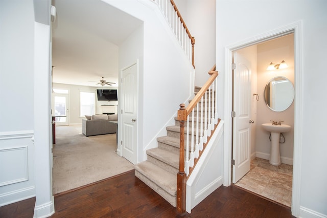 stairway featuring hardwood / wood-style flooring and ceiling fan