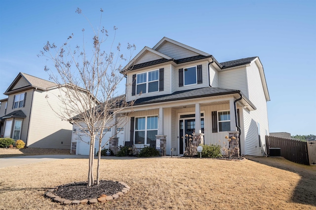 craftsman-style home featuring a garage, cooling unit, and covered porch