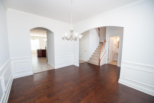 unfurnished dining area with crown molding, dark hardwood / wood-style floors, and a notable chandelier