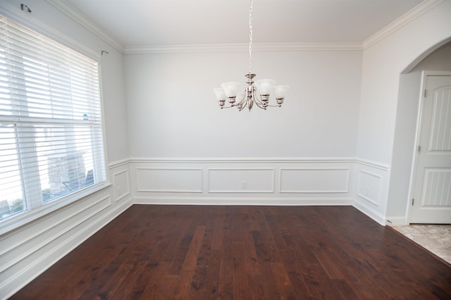 unfurnished dining area featuring an inviting chandelier, dark wood-type flooring, and ornamental molding