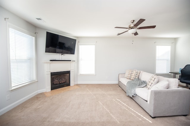 living room featuring ceiling fan, plenty of natural light, and light carpet