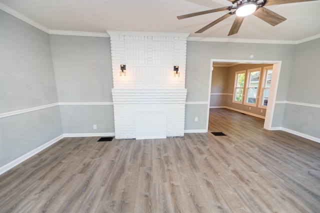 unfurnished living room featuring a fireplace, light hardwood / wood-style flooring, ornamental molding, and ceiling fan