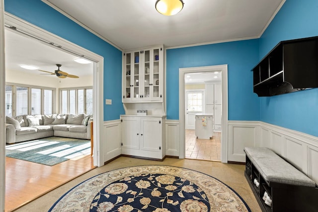 interior space featuring white cabinetry, ornamental molding, and ceiling fan