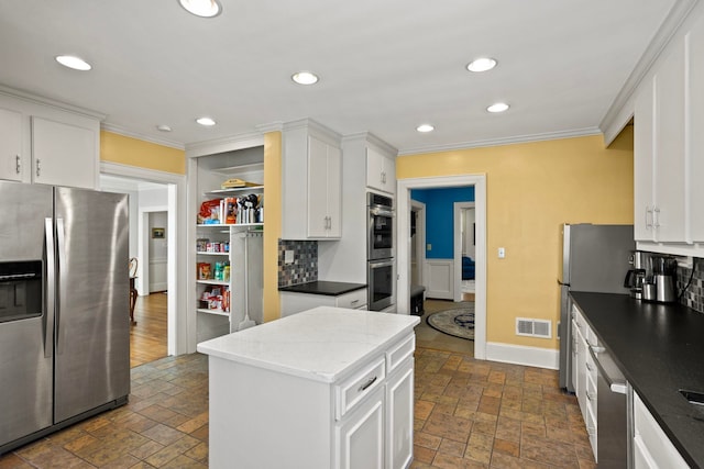 kitchen featuring crown molding, appliances with stainless steel finishes, and white cabinets