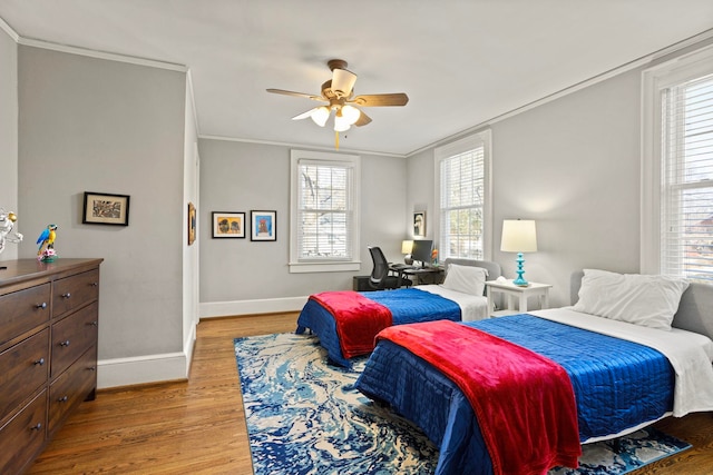 bedroom with crown molding, light hardwood / wood-style flooring, and ceiling fan