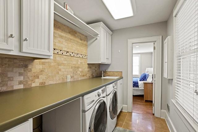 washroom featuring cabinets, sink, tile patterned flooring, and washing machine and dryer