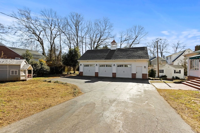 view of side of home featuring a garage, an outdoor structure, and a lawn