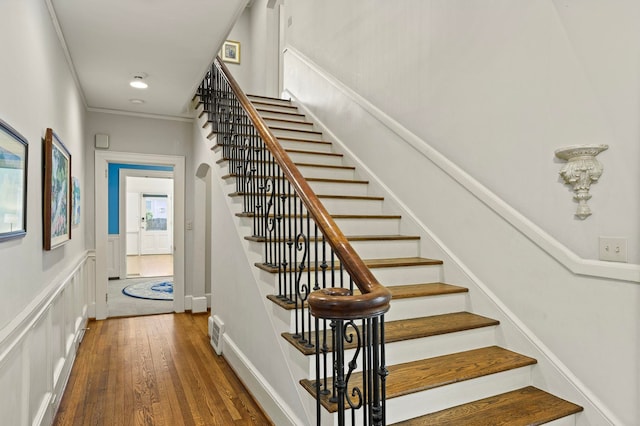 stairs featuring hardwood / wood-style flooring and ornamental molding