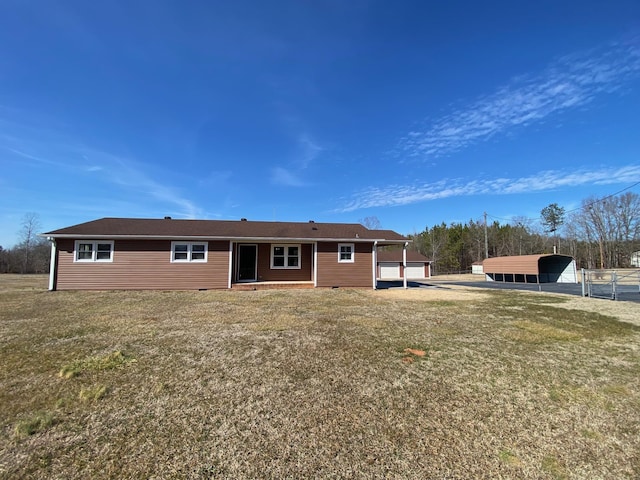 rear view of house featuring a lawn and a carport