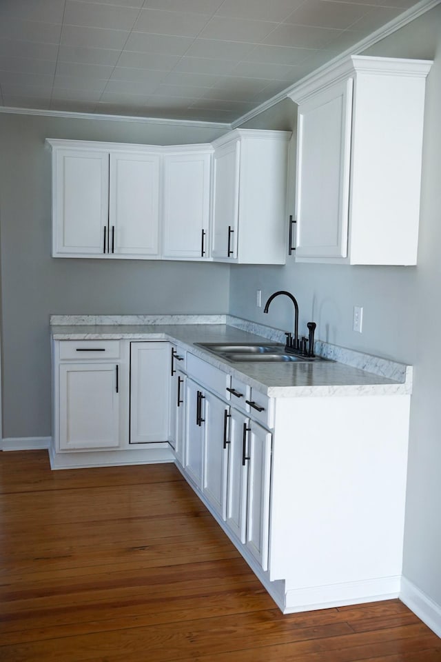 kitchen with sink, crown molding, dark wood-type flooring, and white cabinets