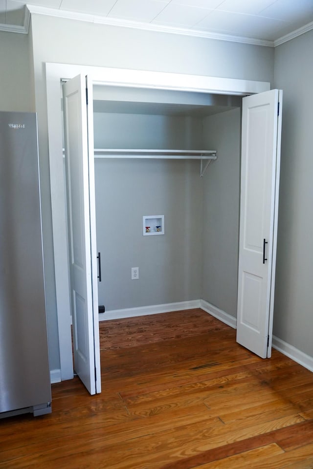 laundry room with hookup for a washing machine, crown molding, and hardwood / wood-style floors