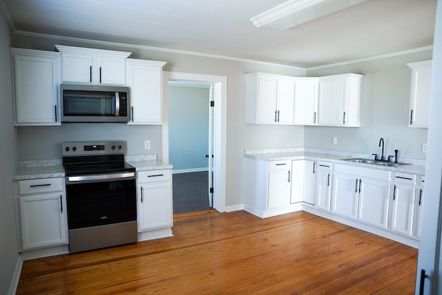 kitchen featuring appliances with stainless steel finishes, dark hardwood / wood-style floors, sink, and white cabinets