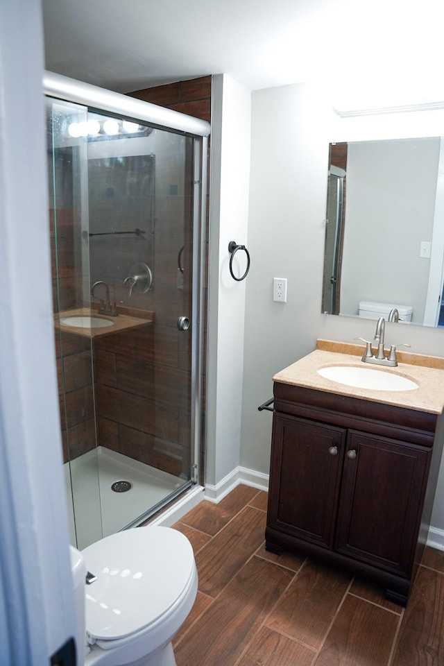 bathroom with vanity, a shower with shower door, and toilet