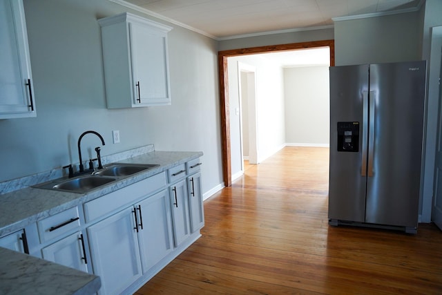 kitchen with sink, crown molding, white cabinetry, stainless steel refrigerator with ice dispenser, and light wood-type flooring