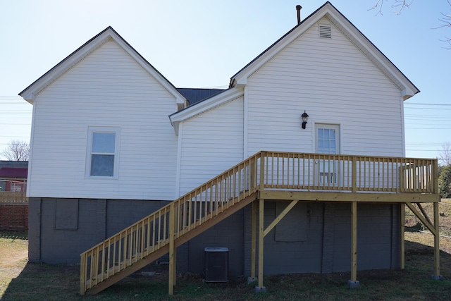 rear view of property with a wooden deck and cooling unit