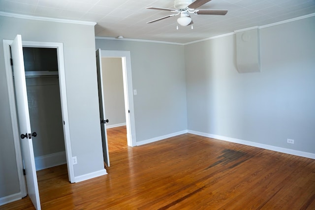 unfurnished bedroom with wood-type flooring, ceiling fan, crown molding, and a closet