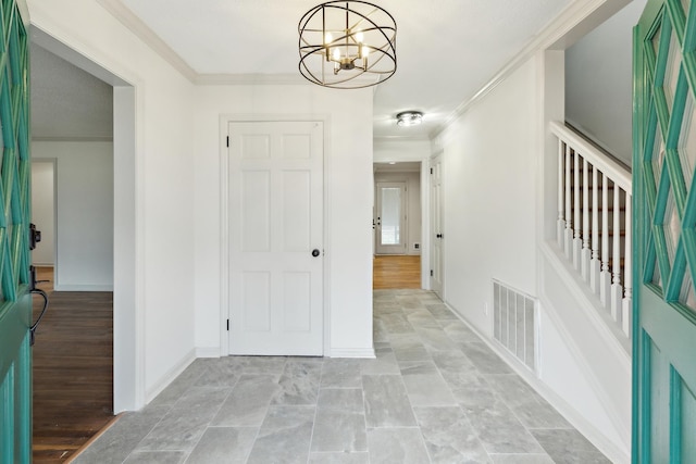 entrance foyer featuring an inviting chandelier and ornamental molding