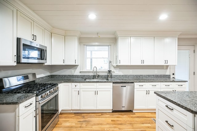 kitchen featuring stainless steel appliances, white cabinetry, and sink