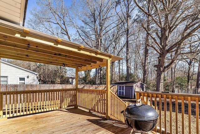 wooden terrace with area for grilling and a storage shed