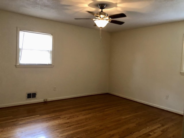 unfurnished room featuring dark wood-type flooring and ceiling fan